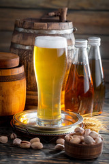 Light beer in a glass on a table in composition with accessories on an old background