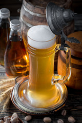 Light frothing beer in a glass, on an old background.