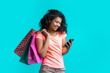 Attractive young dark skinned woman with a bunch of shopping bags