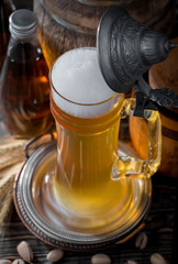 Light frothing beer in a glass, on an old background.