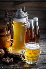Light beer in a glass on a table in composition with accessories on an old background