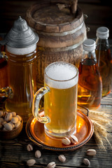 Light frothing beer in a glass, on an old background.