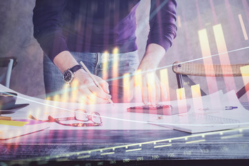 Multi exposure of man standing and planing investment with stock market forex chart.