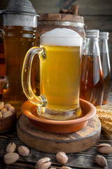 Light frothing beer in a glass, on an old background.