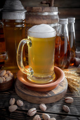 Light frothing beer in a glass, on an old background.