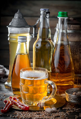 Light beer in a glass on a table in composition with accessories on an old background
