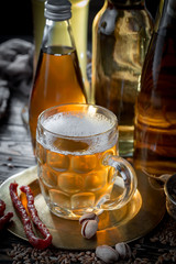 Light beer in a glass on a table in composition with accessories on an old background