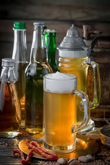 Light frothing beer in a glass, on an old background.