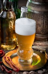 Light beer in a glass on a table in composition with accessories on an old background