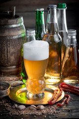 Light frothing beer in a glass, on an old background.