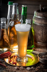 Light beer in a glass on a table in composition with accessories on an old background