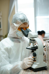 Man Scientist do research in the laboratory with microscope and tubes