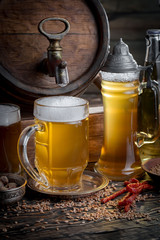 Light frothing beer in a glass, on an old background.
