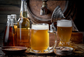 Light frothing beer in a glass, on an old background.