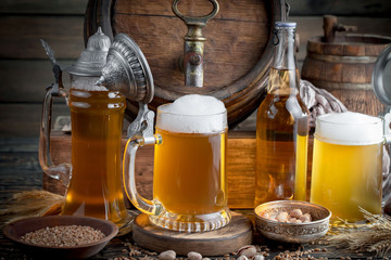 Light frothing beer in a glass, on an old background.