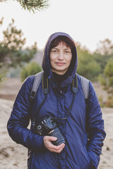 Portrait of a woman with a camera in her hands. Photographer.