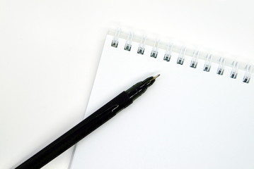 black pen and Notepad with springs on a white background