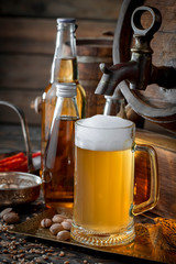 Light frothing beer in a glass, on an old background.