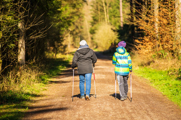A mother and her son  do nordic walking on a forest path during the corona virus lockdown in...