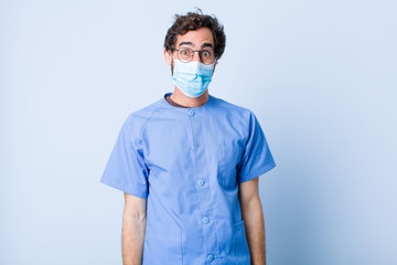 young man looking happy and goofy with a broad, fun, loony smile and eyes wide open. coronavirus...