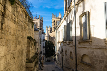 Vue sur la Cathédrale Saint-Pierre de Montpellier depuis une ruelle du centre historique de la ville (Occitanie, France) - obrazy, fototapety, plakaty