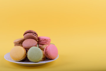 Colorful macaroons cake, sweet macaroon on yellow background, food background