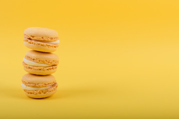 Colorful macaroons cake, sweet macaroon on yellow background, food background