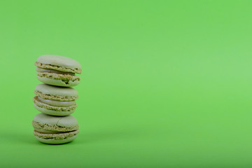 Colorful macaroons cake, sweet macaroon on green background, food background