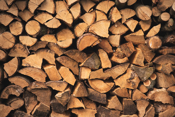 Pile of firewood on a heap. Diversity coniferous and deciduous stacks of firewood.