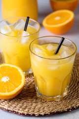 Tasty and Refreshing Orange Juice in Glasses with Black Straws on Light Gray Background Fresh Ripe Oranges Vitamin or Detox Drink Vertical