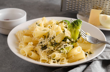 pasta with spinach on a fork on a brown background