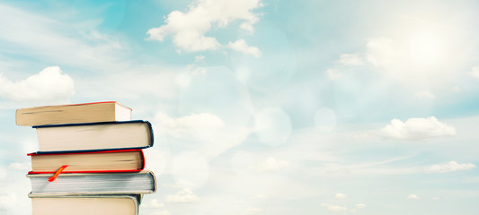 Stack of books silhouetted against bright spring sky