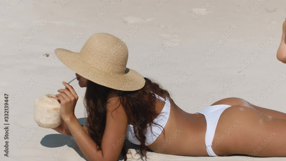 Wall mural Tanned Woman in Bikini with Coconut on the Beach