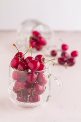 Ripe cherries in a netted cup on a white background