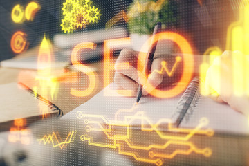 Multi exposure of woman's hands making notes with SEO icon. Concept of Search engine optimization