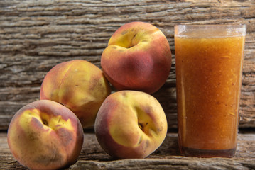 Peach fruits (Prunus persica) in natura on a woody background