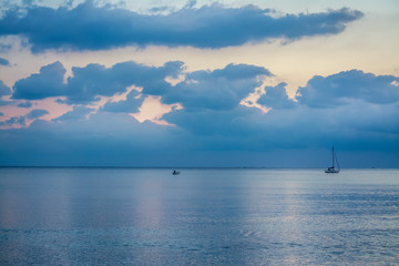 Naklejka na ściany i meble Boats under a grey sky at sunset