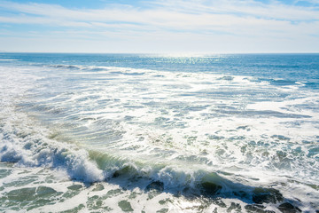 Fototapeta na wymiar Waves in Pacific Beach shore under a sunny sky