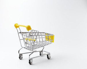 An empty shopping cart with a yellow handle on a white background. Space for text. Rear view