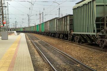 freight train standing next to the platform