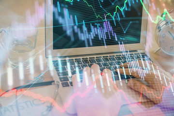 Multi exposure of market chart with man working on computer on background. Concept of financial...