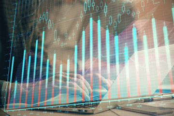 Double exposure of market chart with man working on computer on background. Concept of financial analysis.