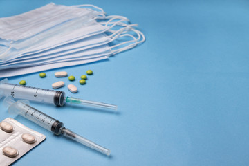 Fototapeta na wymiar Epidemic background. Syringes, mask, medicines. Blue background