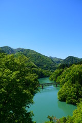 Fototapeta na wymiar 新緑の只見川と只見線第三橋梁。三島、福島、日本。5月中旬。