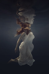 Portrait of a girl in a beautiful dress underwater