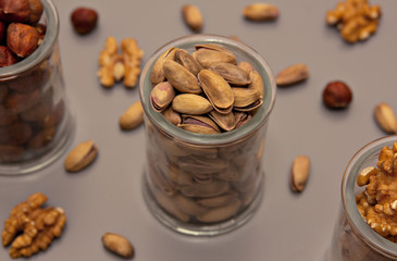 hazelnut, walnut and pistachio nut. mixed assorted nuts in glass box on light background.