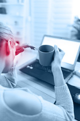 Fototapeta na wymiar Woman feeling unwell, headache while working on a laptop.