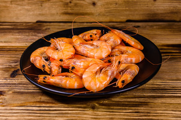 Plate with raw shrimps on a wooden table