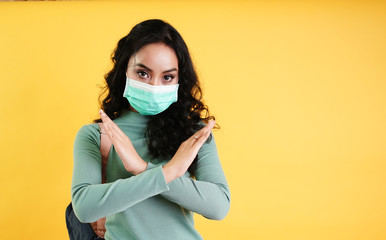 Asian woman in protective medical mask show stop no sign X, crossed arms. Air pollution. Protection of coronavirus pandemic of Chinese virus. NCoV 2019