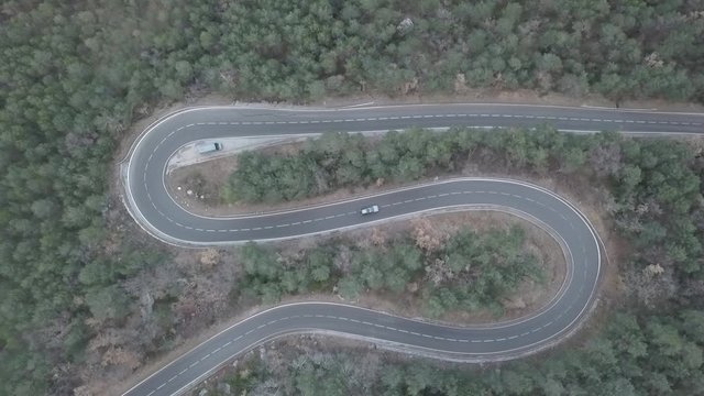 Cars Driving On Winding Road From Above In Forest